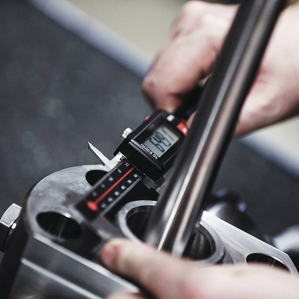 Valve diameters are checked for accuracy using a digital caliper